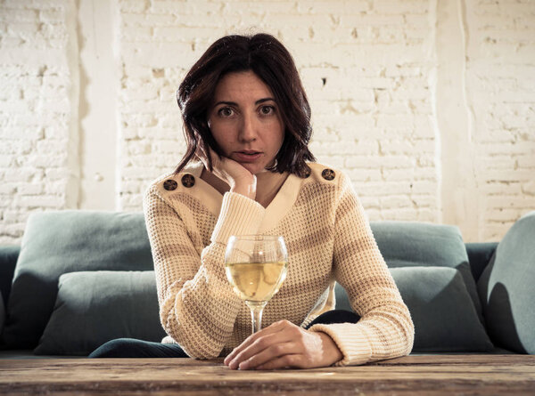 Портрет подавленной женщины, пьющей бокал вина в одиночестве дома. Чувствуя себя несчастным, безнадежным и разочарованным, пытаясь чувствовать себя лучше, выпивая. Нездоровое поведение, депрессия и алкоголь
.