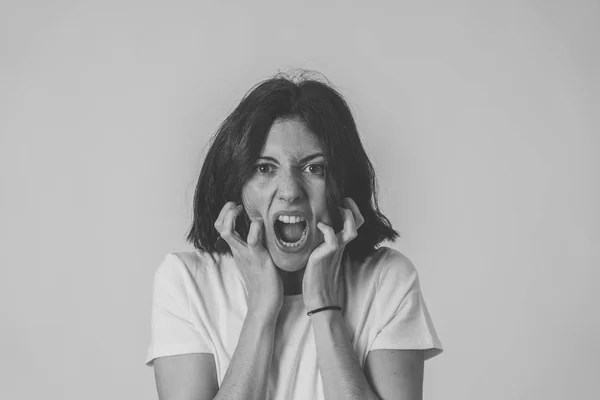 Retrato de una hermosa joven con la cara enojada mirando furiosa. Expresiones y emociones humanas — Foto de Stock