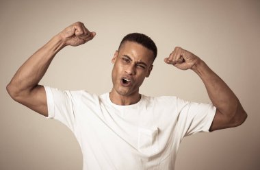 Genç güçlü yakışıklı African Amerikan adam gösteren silah kasları gülümseyen gurur eğleniyor. İnsanlar, mutluluk, Fitness, başarı ınsan duygular ve yüz ifadeleri kavramı.