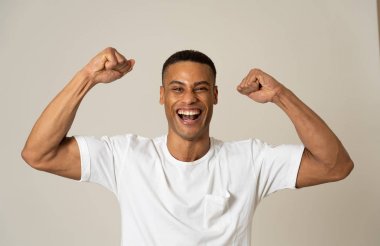 Onun amacı gerçekleştirme veya yeme Afrika kökenli Amerikalı adam hayret portresi heyecanlı, gösteren gülen zafer jest mutlu yüz yüz ifadesi, insan duygularını mutluluk. Gri arka plan üzerinde izole.