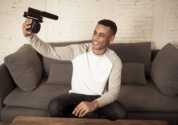 Life style portrait of young happy male blogger on camera screen filming a video tutorial for the internet. Millennial people, new fashion and modern technology, freelance and creative work concept.