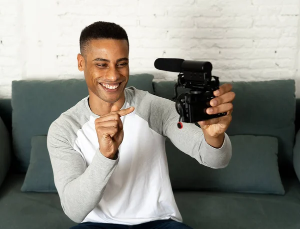Life style portrait of young happy male blogger on camera screen filming a video tutorial for the internet. Millennial people, new fashion and modern technology, freelance and creative work concept.