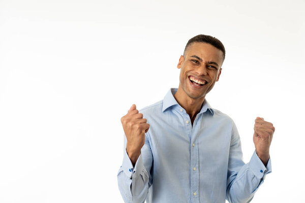 Studio portrait of young african american business man celebrating success. Arms up feeling happy. Isolated on neutral background with copy space. In people business and career education concept.