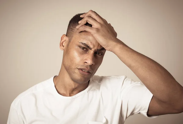 Close up portrait of handsome young african american man with headache suffering from migraines, hands on temples eyes closed showing strong pain. Facial expressions, people and Health care concept.