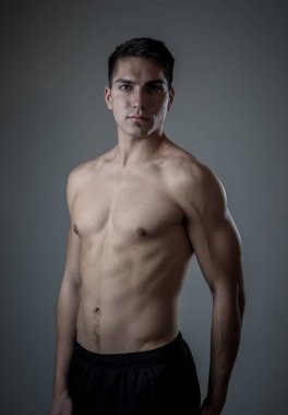 Güçlü yakışıklı atletik genç adam nötr arka planda izole. Karışık yarış Latin kaslı model Fitness pazarlama reklam için poz. Egzersiz, sağlıklı yaşam, egzersiz ve vücut bakımı.