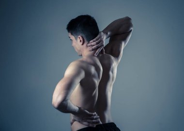 Genç Kas Fitness adam dokunmadan ve boyun ve alt sırt acı servikal ağrı nötr arka planda izole kapma. Spor ve egzersiz yaralanması, yanlış duruş sorunları ve vücut bakımı.