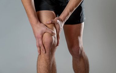 Genç fit adam kas yaralanması zarar kemik bacak ağrısı burkulma veya kramp çalışan egzersiz sırasında acı elleri ile diz tutarak. İçinde vücut ağrısı ve spor eğitim yaralanma ve vücut sağlık bakımı.