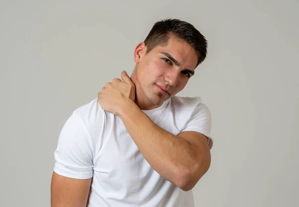 年轻的肌肉健身男子触摸和抓住他的脖子和上背部遭受颈椎疼痛隔离在中性背景 在运动损伤不正确的姿势问题和身体保健 — 图库照片