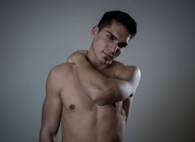 Genç kaslı uygun adam dokunmadan ve kapma boyun ve üst sırt acı servikal ağrı egzersiz sonra. Nötr arka planda izole. Spor yaralanması yanlış duruş sorunları ve vücut sağlık bakımı.