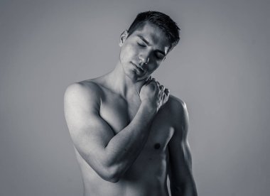 Genç kaslı uygun adam dokunmadan ve kapma boyun ve üst sırt acı servikal ağrı egzersiz sonra. Nötr arka planda izole. Spor yaralanması yanlış duruş sorunları ve vücut sağlık bakımı.