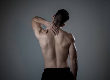 Genç kaslı uygun adam dokunmadan ve kapma boyun ve üst sırt acı servikal ağrı egzersiz sonra. Nötr arka planda izole. Spor yaralanması yanlış duruş sorunları ve vücut sağlık bakımı.
