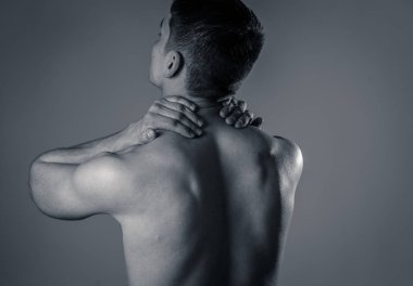 Genç kaslı uygun adam dokunmadan ve kapma boyun ve üst sırt acı servikal ağrı egzersiz sonra. Nötr arka planda izole. Spor yaralanması yanlış duruş sorunları ve vücut sağlık bakımı.
