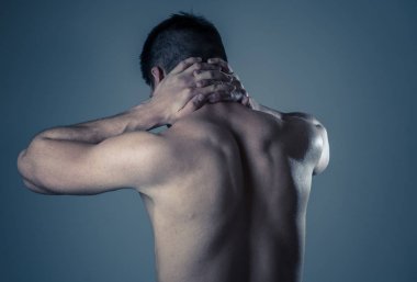 Genç kaslı uygun adam dokunmadan ve kapma boyun ve üst sırt acı servikal ağrı egzersiz sonra. Nötr arka planda izole. Spor yaralanması yanlış duruş sorunları ve vücut sağlık bakımı.