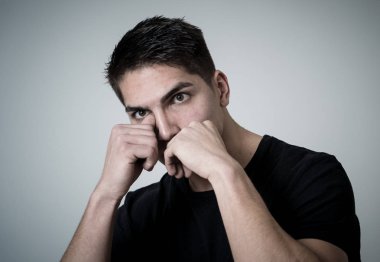 Bir argüman ya da mücadele sahip savunma duruş öfkeli görünümlü öfkeli yüzü ile çekici bir genç adamın portre yakın. Nötr arka planda izole. Insanlar, boks ve olumsuz duygular.