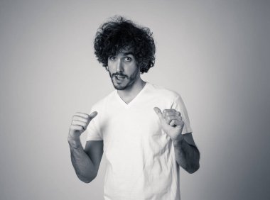 Ayı ve büyük saç gülümseyen ve komik ve dost jestleri yapma neşeli genç milenyal erkek stüdyo çekim. Nötr arka planda izole. İnsan ifadeleri ve reklam konsepti.