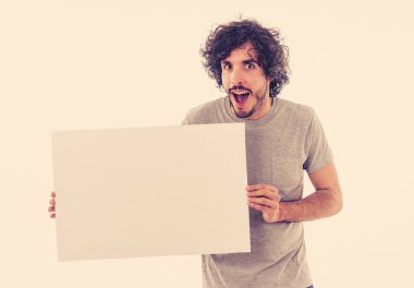 Harika bir ürün ya da şaşırtıcı satış veya büyük reklam gösterir gibi heyecanlı görünümlü metin için kopya alanı ile boş poster gösteren komik ve çekici milenyal adam. Stüdyo vurdu. Pazarlama konsepti.