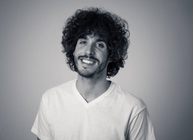 Mutlu yüz, güzel gülümseme ve komik saç tarzı ile çekici genç model portresi. 20 ' li yılların yakışıklı bin yıllık adamı. Stüdyo çekimi. Insanlar, moda ve insan yüz ifadeleri ve duygular.