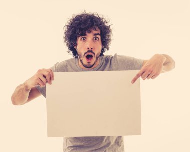 Harika bir ürün ya da şaşırtıcı satış veya büyük reklam gösterir gibi heyecanlı görünümlü metin için kopya alanı ile boş poster gösteren komik ve çekici milenyal adam. Stüdyo vurdu. Pazarlama konsepti.