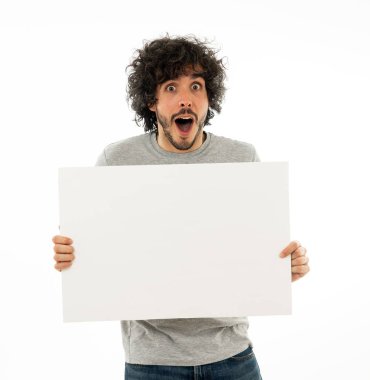 Harika bir ürün ya da şaşırtıcı satış veya büyük reklam gösterir gibi heyecanlı görünümlü metin için kopya alanı ile boş poster gösteren komik ve çekici milenyal adam. Stüdyo vurdu. Pazarlama konsepti.