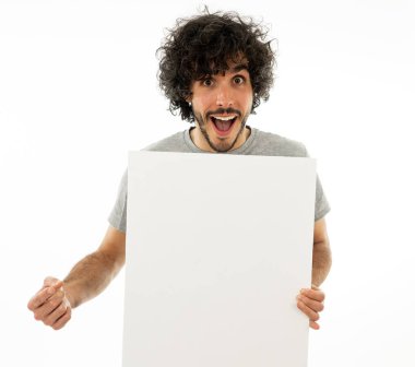 Komik ve iyi görünümlü milenyal adam gösteren ve metin için kopya alanı ile boş tahta işaret. Samimi ve heyecanlı genç şık adam reklam için boş poster tutuyor. Pazarlama konsepti.