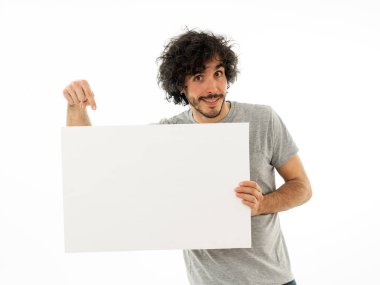 Komik ve iyi görünümlü milenyal adam gösteren ve metin için kopya alanı ile boş tahta işaret. Samimi ve heyecanlı genç şık adam reklam için boş poster tutuyor. Pazarlama konsepti.