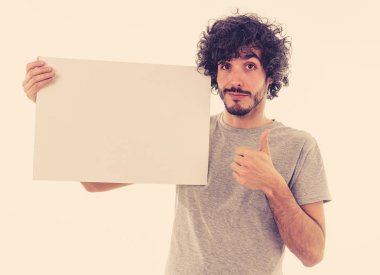 Komik ve iyi görünümlü milenyal adam gösteren ve metin için kopya alanı ile boş tahta işaret. Samimi ve heyecanlı genç şık adam reklam için boş poster tutuyor. Pazarlama konsepti.