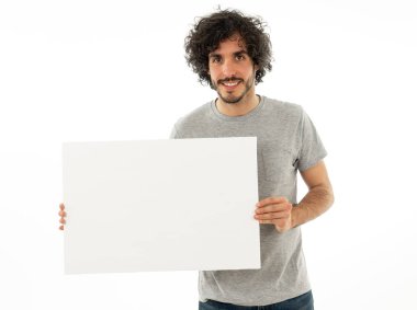 Komik ve iyi görünümlü milenyal adam gösteren ve metin için kopya alanı ile boş tahta işaret. Samimi ve heyecanlı genç şık adam reklam için boş poster tutuyor. Pazarlama konsepti.