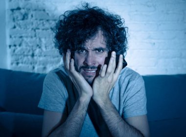 TV 'de korku filmi ya da hoş olmayan şiddet sahnesi izlerken genç nefret adam Lifestyle portre. Geceleri evde korku ve şok. Kitle iletişim alanında şiddet, eğlence ve morbid gösterileri.