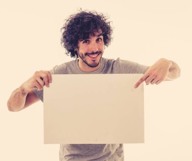 Harika bir ürün ya da şaşırtıcı satış veya büyük reklam gösterir gibi heyecanlı görünümlü metin için kopya alanı ile boş poster gösteren komik ve çekici milenyal adam. Stüdyo vurdu. Pazarlama konsepti.