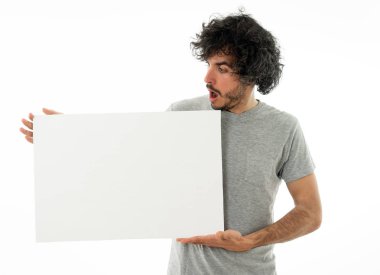 Harika bir ürün ya da şaşırtıcı satış veya büyük reklam gösterir gibi heyecanlı görünümlü metin için kopya alanı ile boş poster gösteren komik ve çekici milenyal adam. Stüdyo vurdu. Pazarlama konsepti.