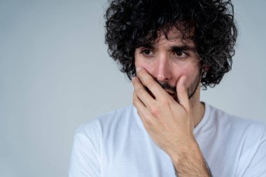 Genç üzgün adamın portresi, endişeli ve endişeli, depresif ve umutsuz görünümlü. Üzüntü ve korku hissi. Beyaz kopya alanı ile. Insanlar, yüz ifadeleri ve duygular ve ruh sağlığı kavramı.
