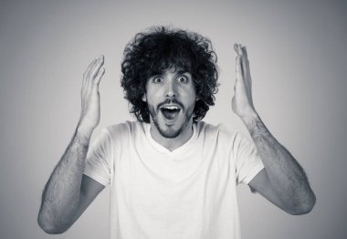 Mutlu ve sürpriz yüz işaret ve şok edici ve iyi bir şey heyecanlı görünümlü ile komik çekici genç adam portresi. İnsan duyguları, yüz ifadeleri. Reklam, satış veya kazanma.