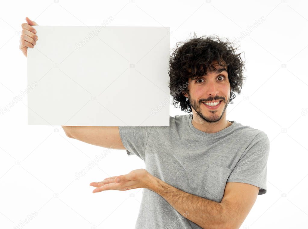 Funny and good looking millennial man showing and pointing at blank board with copy space for text. Friendly and excited young stylish man holding blank poster for advertisement. In marketing concept.