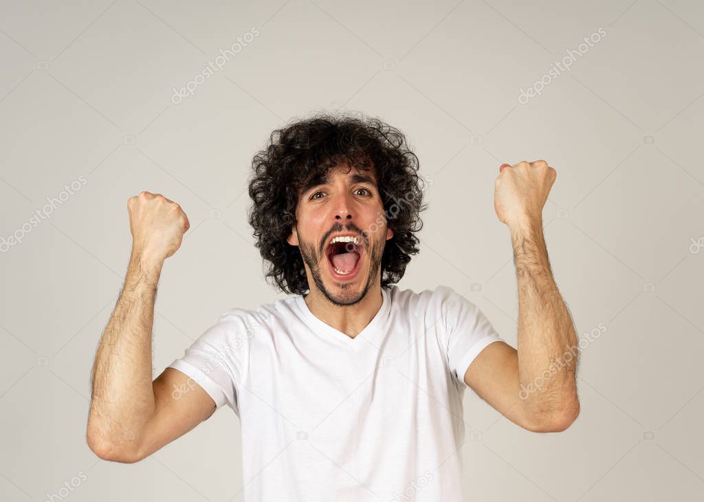 Portrait of young happy and shocked man winning the lottery or having great success with surprised face and celebration gestures. In People Facial Expression and positive Human Emotions. Studio shot.