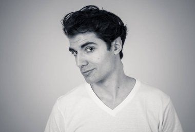 Siyah beyaz portre genç hassas adam sevgi duygu mutlu, utangaç ve şanslı görünümlü. Nötr arka planda izole edilmiş. İnsanlarda olumlu insan duyguları, yüz ifadeleri ve vücut dili.