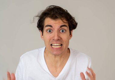 Genç adam korkar ve korku ve anksiyete içinde korkmuş jestler yapma şok hissediyor. Korkmuş ve çaresiz kendini örtbas etmeye çalışıyor. Boşluk Kopyala. İnsanlar ınsan ifadeleri ve duygusal reaksiyonlar.