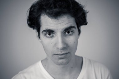 Doğal ve ciddi yüz ve komik bir görünüm ile Genç Latin adam headshot kapatın. Nötr arka planda izole. Insanlar, moda, yaşam tarzı güzellik ve insan duyguları kavramı.