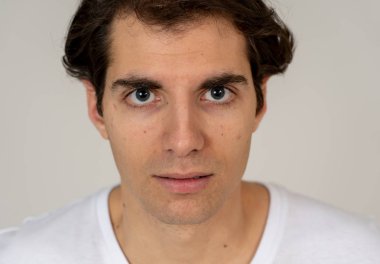 Doğal ve ciddi yüz ve komik bir görünüm ile Genç Latin adam headshot kapatın. Nötr arka planda izole. Insanlar, moda, yaşam tarzı güzellik ve insan duyguları kavramı.