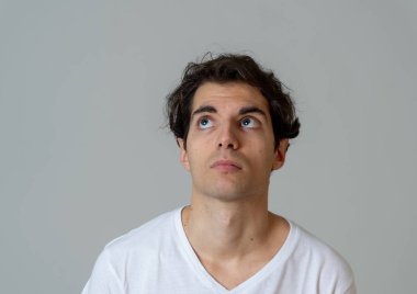 Komik yüzler düşünüyorum. Endişeli genç adamın portresi karıştı. Yeni fikirler, başarı için yaratıcı yollar, yeni diller öğrenme veya eğitim düşünceli erkek düşünme. Nötr arka planda yalıtılmış.