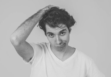 Komik yüzler düşünüyorum. Endişeli genç adamın portresi karıştı. Yeni fikirler, başarı için yaratıcı yollar, yeni diller öğrenme veya eğitim düşünceli erkek düşünme. Nötr arka planda yalıtılmış.