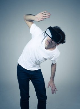 Sanal gerçeklik gözlükleri kullanan genç adam, korkutucu bir VR macerasına sahip korkmuş jestler yapan sanal dünyayı keşfetmek için heyecanlı ve şok hissediyor. Yenilik yeni teknoloji ve sanal Augmented gerçeklik.