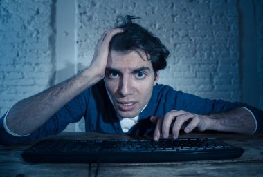 Bilgisayar laptop çalışma, online kumar, porno izlerken veya evde geç veya internet sohbet sosyal medya ağı kullanarak oyun oynarken tek başına gece yalnız bağımlısı genç adam. Teknoloji bağımlılığı.