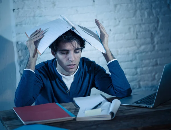 stock image Overworked and Stressed young student preparing exams late at night on laptop feeling distressed fatigued tired worried and sad. Moody dark light. Online learning, University education and stress.