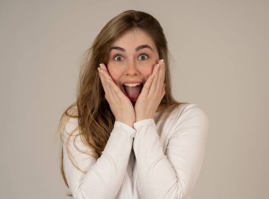 Güzel genç sarışın genç kadın mutlu yüz sürpriz jestleri görünümlü ve şok edici ve iyi bir şey işaret yapıyor. İnsan yüz ifadeleri ve duygular. Kopya alanı ile portre.