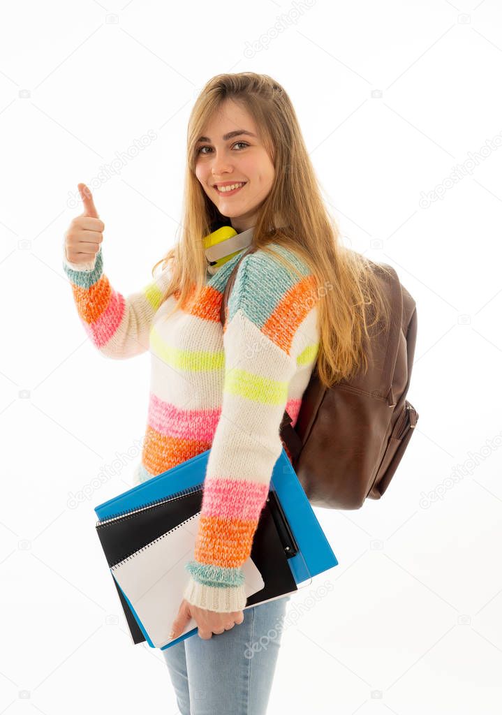 Portrait of attractive blonde student teenager girl making thumbs up gesture feeling successful and happy against white background In people, Education and success concept.