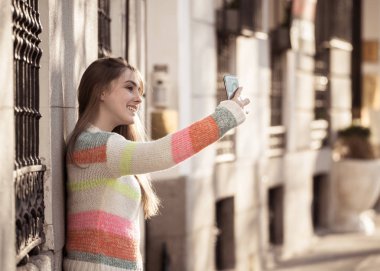 Güzel genç kız selfie mutlu ve şehirde heyecanlı alıyor. Genç öğrenci kadın kayıt video kendini blog açık havada Millennial nesil Connections teknoloji ve online trendleri.