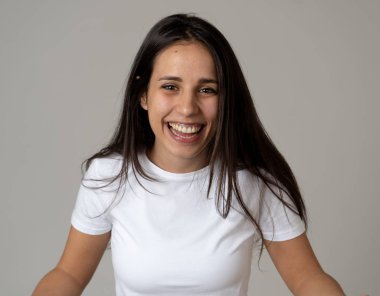 Mutlu yüz güzel gülümseme ve uzun siyah saçlı çekici esmer genç latin kadının yakın portresi. Nötr arka planda izole edilmiş. İnsanlarda, olumlu insan yüz ifadeleri ve duygular.