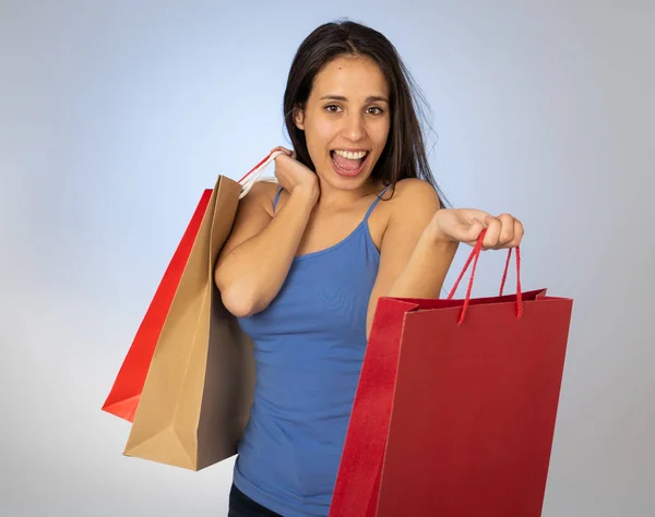 買い物の日の後に幸せで陽気なカラフルなバッグを持つ幸せなラテンの若い女性 新しいシーズンの販売で購入紙袋で興奮ティーンエイジャー ファッションとショッピング中毒の概念 — ストック写真