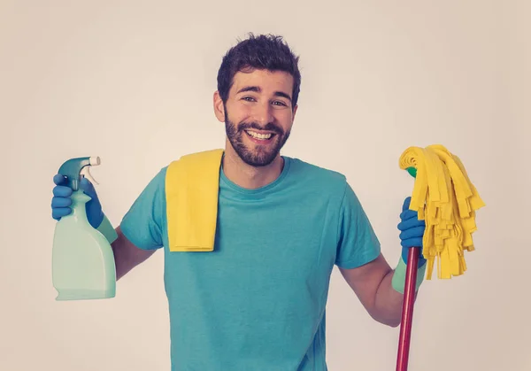 Breaking gender stereotypes. Portrait of attractive happy man proud holding cleaning equipment ready to do housework. isolated on blue background. In changing men and women roles in society.