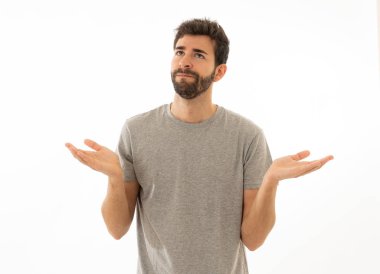 Çekici genç adam portresi hiçbir fikrim yok yüzünde belirsizlik ve habersiz ve sorgulanan bir görünüm ile el ele tutuşarak habersiz jest yapıyor. Beyaz arka planda izole edilmiş. İnsan ifadesi.